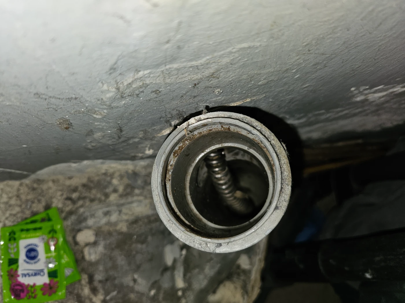 Widok z góry w otwarty trójnik 50 mm, w środku stalowa spirala elektrycznej sprężyny, która oparła się o ściankę kształtki